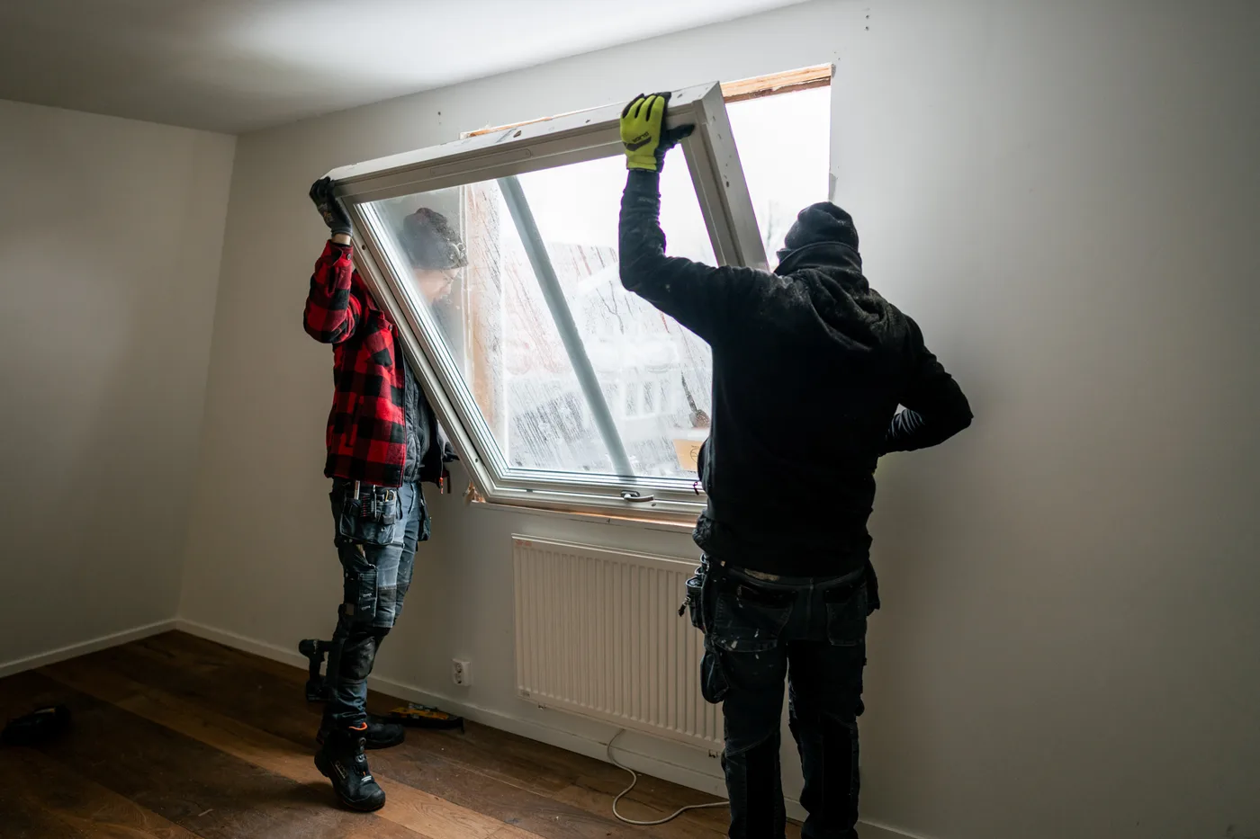 Två montörer installerar fönster
