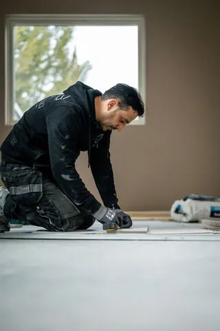 Montör utför golvarbete vid fönster